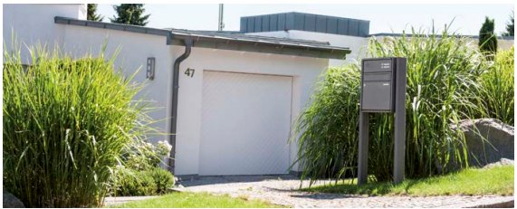 RENZ QUADRA Briefkastenanlage freistehend vor modernem Haus mit Gräsern